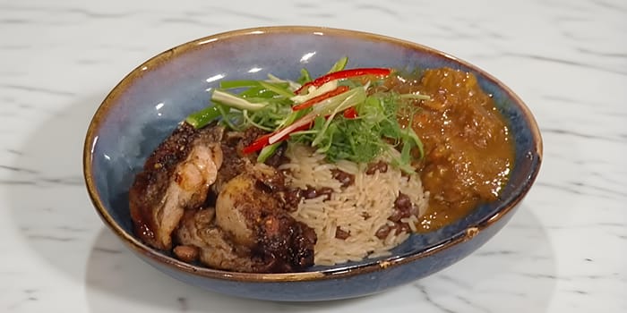 Curry goat and jerk chicken with rice and peas