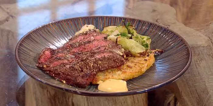 Pastrami-spiced bavette with charred cabbage served on a brown plate