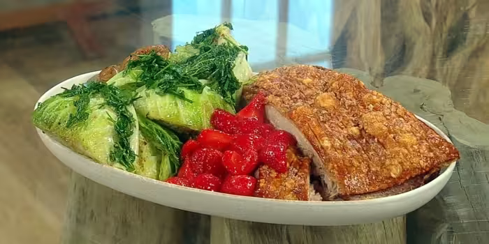 Crispy-pork-belly-with-caramelised-strawberries-cider-sauce-herb-roasted-potatoes-and-charred-cabbage-wedges.avif